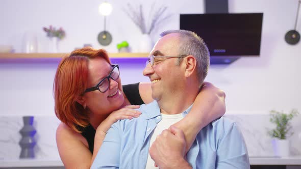 Portrait of Mature Couple Sitting and Smiling in Living Room