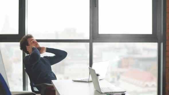 Handsome Bearded Male Entrepreneur Using Laptop While Sitting in Coworking Space