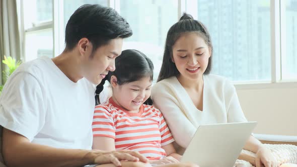 Asian family mom dad daughter laugh smile spending weekend moment together at home