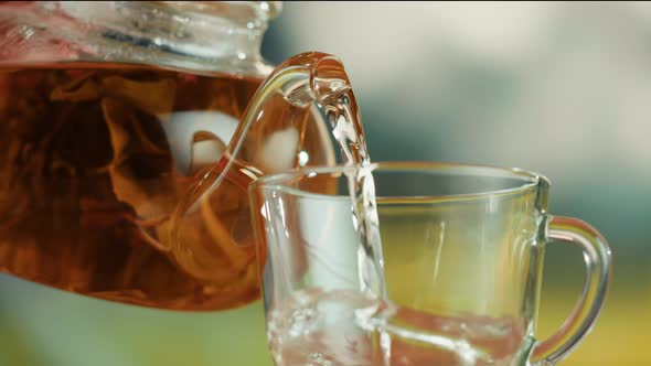 Pouring Fresh Tea in Glass Cup Closeup