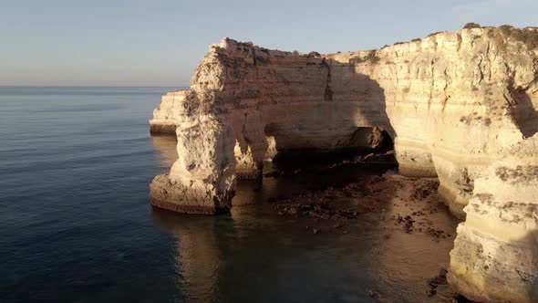 Aerial view of cliff arch during sunrise at Marinha Bay