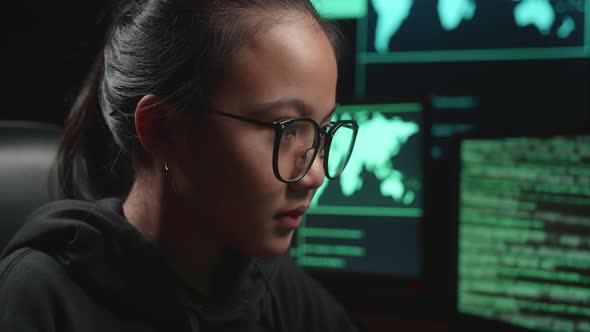 Asian Young Girl Hacker Hacking With Multiple Computer Screens In Dark Room