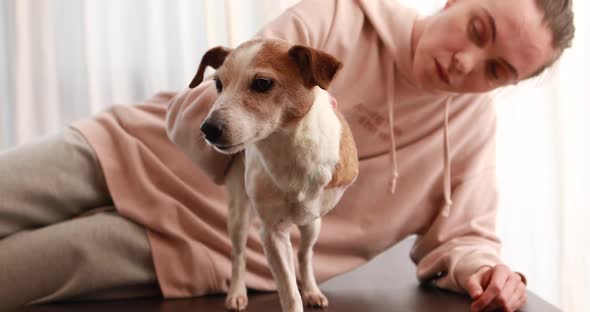 Pet Owner Supports the Threelegged Dog Sitting at Table