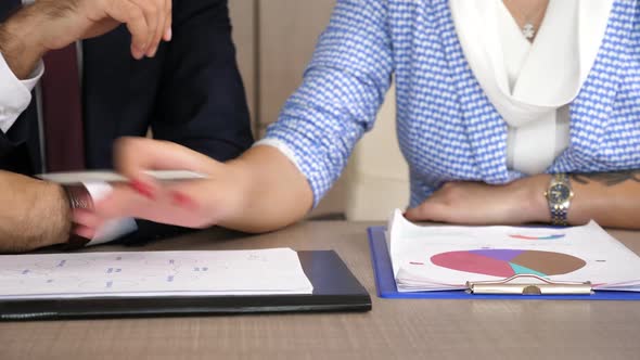 Businesswoman Talking with His Colleague and Analyzing Charts and Diagrams with Sales