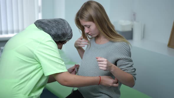 Smiling Pregnant Young Woman in Hospital with Obstetrician Measuring Belly with Tape Talking