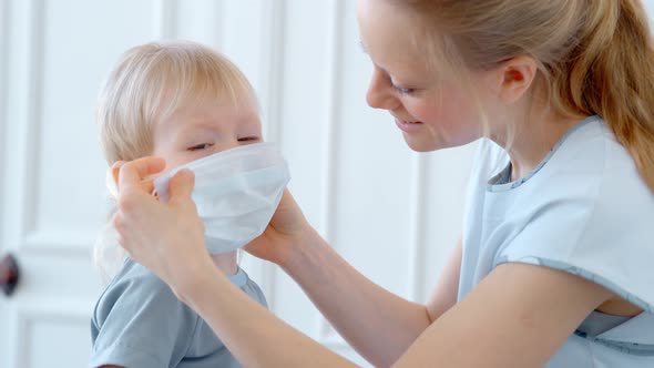 Concept, Family During Quarantine Self-isolation. Mom Puts Her Son in a Mask for Protection.