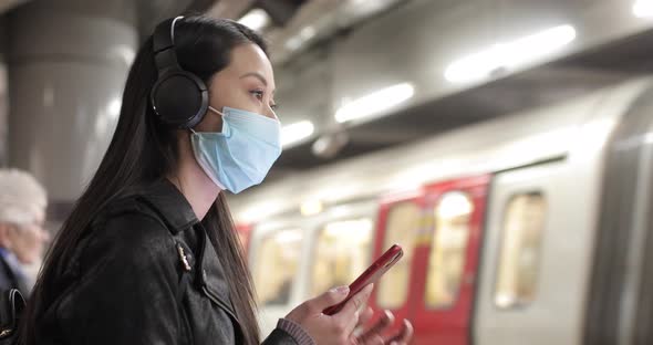 Chinese woman at train station in London wearing face mask