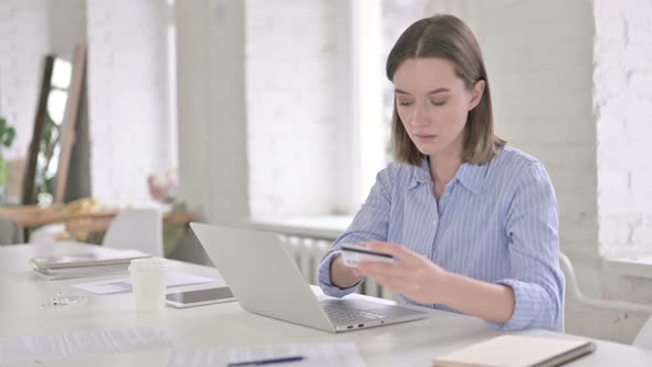 Cheerful Woman Making Online Payment By Credit Card in Office