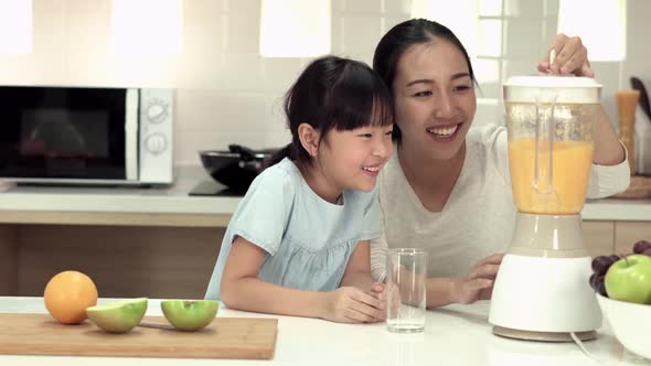 Woman and little girl making smoothie