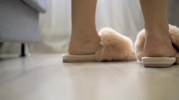 female feet get out of bed put on shaggy pink slippers and go away