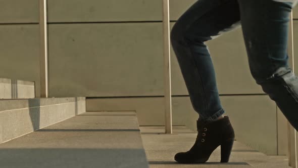 Legs of a Cheerful Girl Jumping Up the Stairs of an Underground Passage or Subway