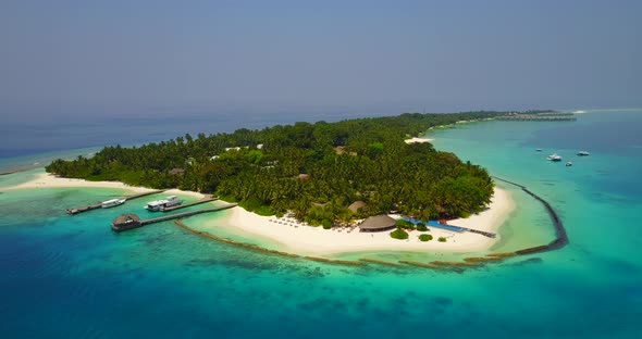 Wide overhead abstract shot of a sandy white paradise beach and blue water background in 4K