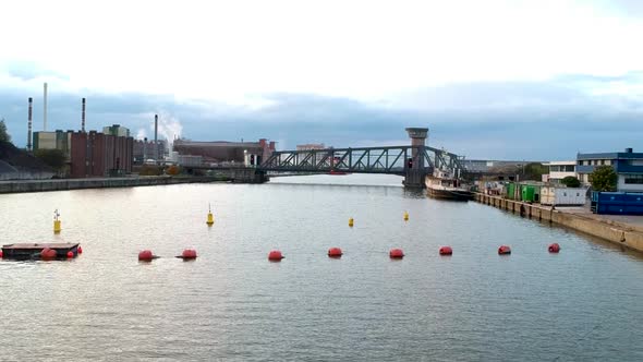 Drone rises over train bridge crossing the Schelde river in Antwerp Belgium