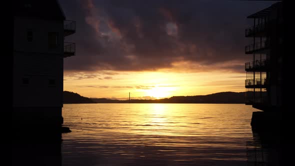 Sunset timelapse of Askoy and bridge seen across byfjorden in Bergen Norway - Silhouette of apartmen