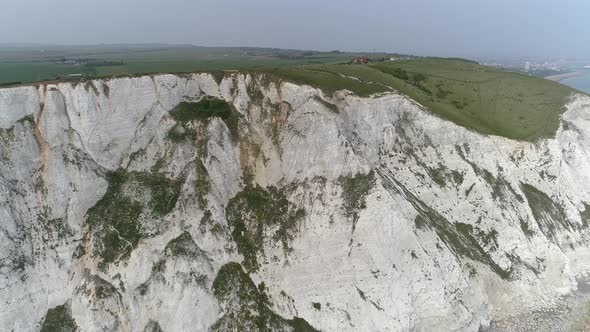 Amazing aerial view of Beachy Head Cliffs, south UK coastline, drone pull back.