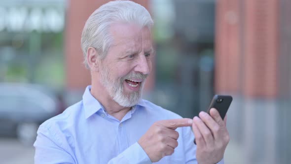 Outdoor Old Man Celebrating Success on Smartphone