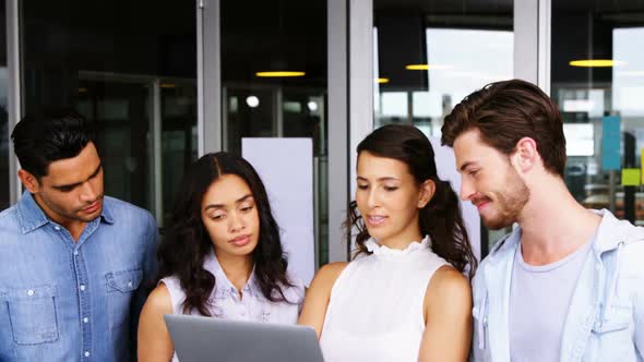 Executives having discussion over laptop