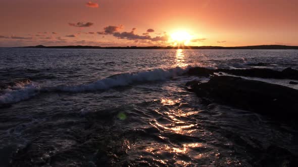 Waves Crashing on Rocks at Sunset