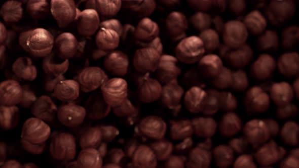 Super Slow Motion Shot of Hazelnuts Flies After Being Exploded Against Black Background 1000Fps