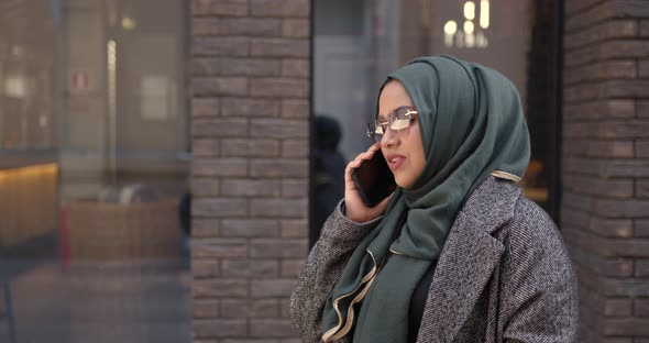 Muslim Woman in Veil Talking By Phone Outdoors