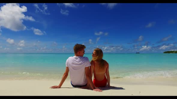 Guy and girl sunbathe on tranquil bay beach journey by shallow sea with white sand background of the