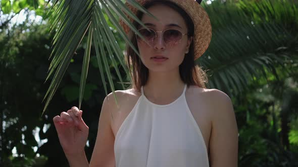 Woman is Playing with Leaf of Palm