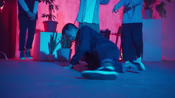 Stylish Male Dancer Moves to Music in a Smoky Room with Neon Lighting