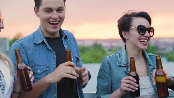 Happy Friends Drinking Beer, Cheering With Bottles And Dancing