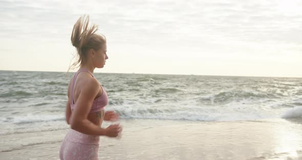 Woman in Sportswear Goes Jogging Along Embankment By Sea