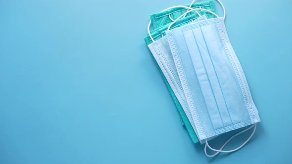 Surgical Masks, Thermometer and Hand Sanitizer on Blue Background 