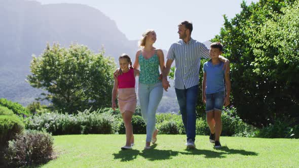 Caucasian family walking together in in the garden on a bright sunny day