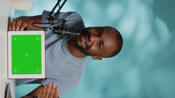 Vertical Video Black Vlogger Showing Tablet with Horizontal Green Screen