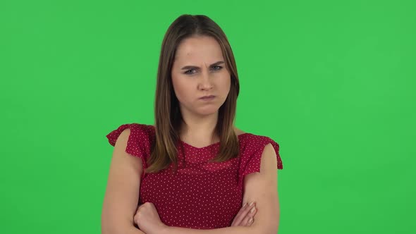 Portrait of Tender Girl in Red Dress Is Very Offended and Looking Away. Green Screen