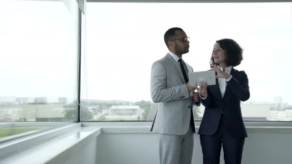 Smiling People Wearing Formal Wear Using Tablet Near Window