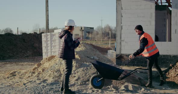 Concentrated Engineers Discussing Examining and Developing at Construction Site