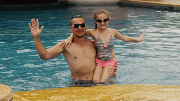 The Father with Little Daughter Have Fun in the Pool. Dad Plays with the Child. The Family Enjoy