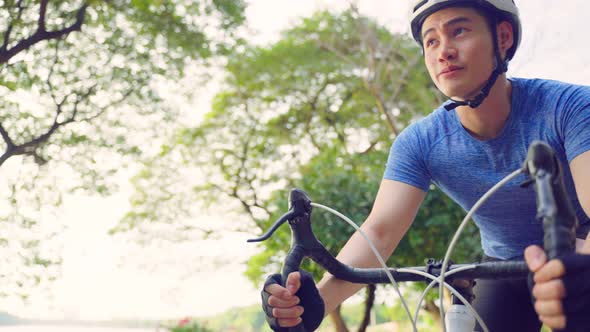 Asian young active sport male riding bicycle for health in public park.