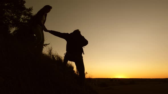 Travel and Adventure Concept. Male Traveler and Female Traveler Descend From Top of the Hill