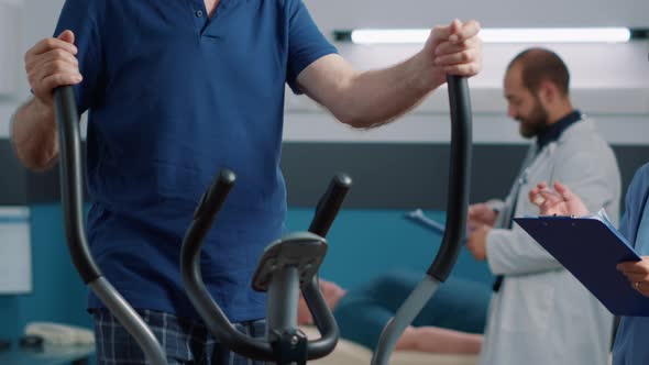 Elder Person Exercising with Stationary Bike at Rehabilitation Clinic