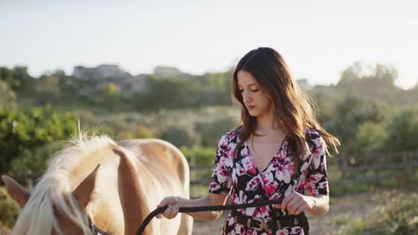 Girl In Flowered Dress Plays with Horse