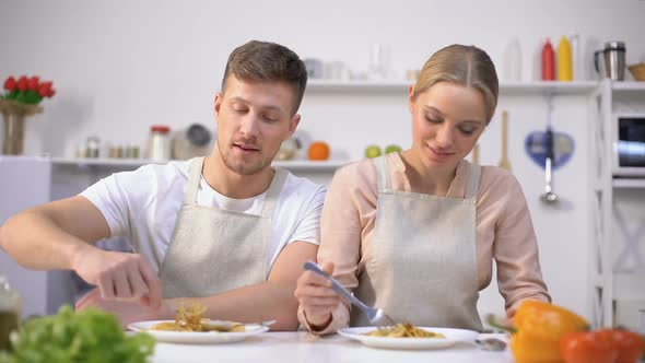 Young Couple Eating Pasta, Smiling on Camera, Concept of Quick and Easy Food