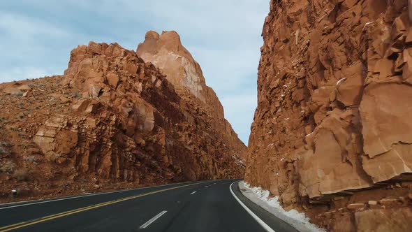 Car Driving on Highway Along Tall Cliffs in Winter. Arizona, USA