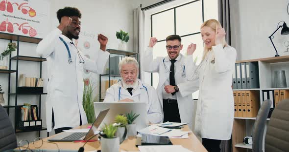 International Team of Doctors Celebrating Joint Victory with Applause During Meeting