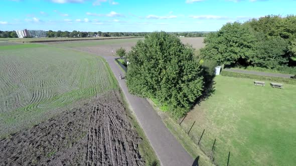 Aerial footage of tree and bikeriders in countryside.