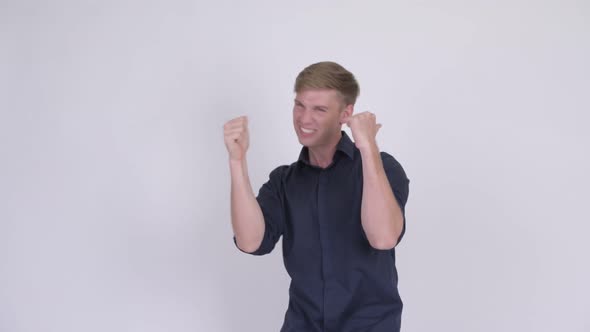 Happy Young Blonde Businessman Giving Thumbs Up and Looking Excited