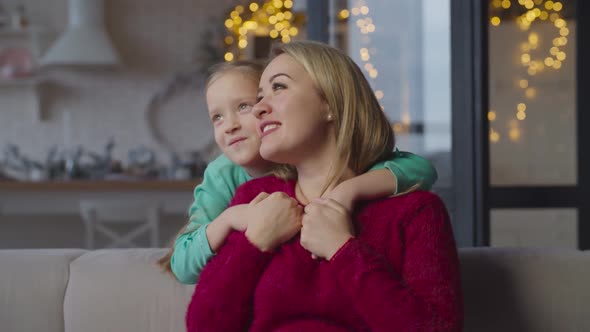 Cute Daughter Hugging Mom with Love and Happiness