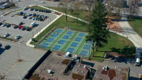 Tennis Players in a City Park, Drone Dolly In over the Sports Courts