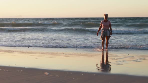 Senior woman walking on beach