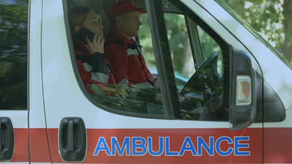 Female Paramedic Using Smartphone to Call Patient, Ambulance Crew On-Duty