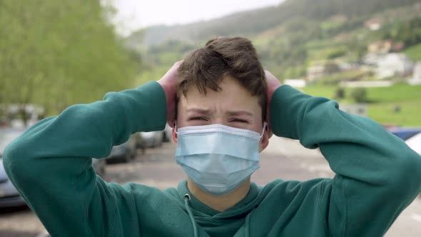 A young man suffers from a headache on the street with cars.